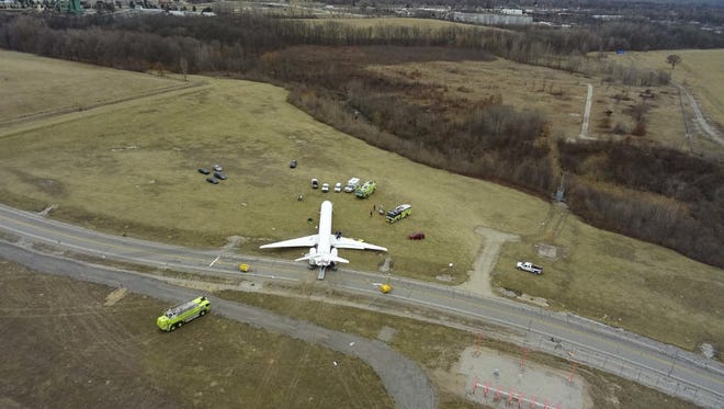A Michigan State Police drone photo shows that the MD-83 slid across an access road and came to rest near a wooded area.