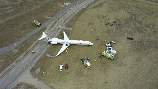 The tail of the University of Michigan's chartered jetliner blocks a road at Willow Run Airport the day after the accident.