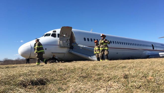 The NTSB has released photos of the March 8, 2017 accident when the University of Michigan's basketball charter airplane skidded 1,000 feet past the end of a runway at Willow Run Airport on a windy day. None of the 116 onboard was seriously injured.  Above, firefighters work at the scene.