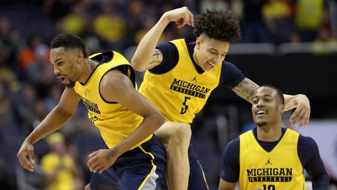The day after the accident, on March 9, 2017, the Michigan team arrived late and wore practice jerseys during their Big Ten Tournament game against Illiinois at the Verizon Center in Washington, D.C. From left, Michigan's 
Zak Irvin, D.J. Wilson and Muhammad-Ali Abdur-Rahkman celebrate after Wilson scored in the first half.