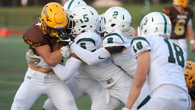 Rochester Adams running back Chase Kareta, left, is stood up by the West Bloomfield defense in the first half during a high school football game.