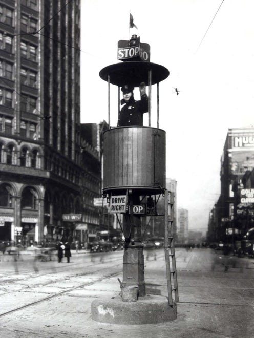 A police officer manually switches the Stop-Go sign on a "street semaphore" on Woodward Avenue in 1928.