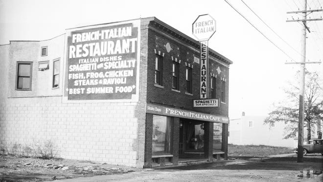 A restaurant in a two-story commercial building advertises French and Italian specialties in 1928.