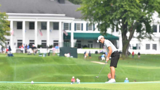 Sam Burns of Shreveport, La., putts on the 11th green with the Oakland Hills Country Club clubhouse in the background prior to the 2016 U.S. Amateur.