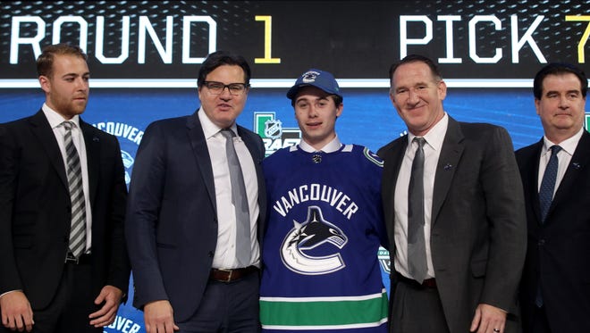 Michigan's Quinn Hughes poses after being selected seventh overall by the Vancouver Canucks during  Friday's NHL Draft.