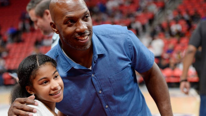 Chauncey Billups, right, poses for photo with Kennedi Goodley, 12, of Detroit before the game.