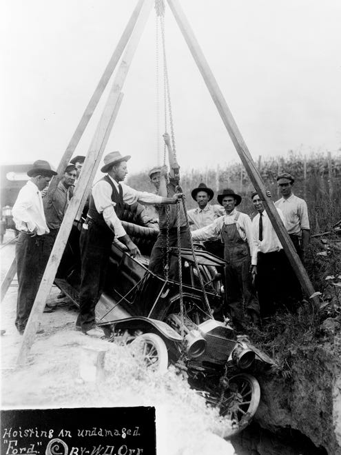 Men use a block and tackle to hoist a Model T Ford from a ditch, circa 1914. Driver's education classes weren't available until the 1930s.