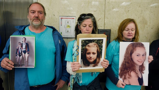 Parents of Nassar victims, from left, Glen Black, 53, of Pinckney, Tammy Bourque-Stemas of Dearborn and Valerie von Frank of Okemos, stand by the elevator waiting for Michigan State University trustees to enter the Hannah Administration Building as they arrive for a board meeting Friday morning, April 13, 2018.