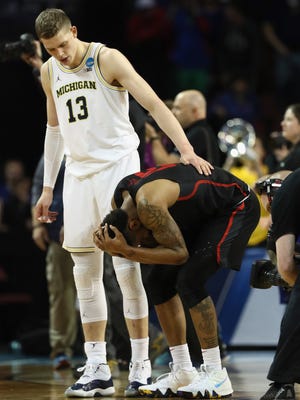 Moritz Wagner of the Michigan Wolverines tries to console Devin Davis, Corey Davis' teammate on the Houston Cougars, after Saturday night's game.