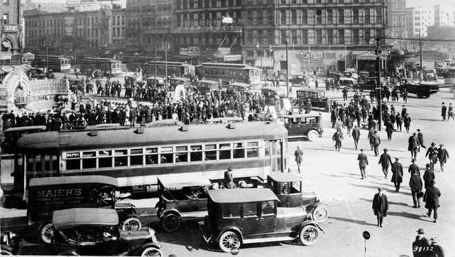 Streetcars, pedestrians and motor vehicles converge at Monroe Avenue and Cadillac Square in 1915.