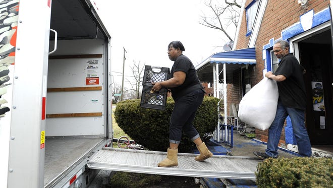 LaTasha Tucker, left, and Richard Johnson, 53, both of Detroit, carry items out of the house. Tucker stopped paying her $500-a-month rent when the landlord refused to fix the sewage backup. While Tucker looked for a new home, she sucked the bio-hazard mix out through a basement window with a garden hose and sump pump three times a week, then lit kiwi-scented incense to mask the smell before her kids would come home from school.