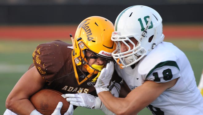Rochester Adams running back Chase Kareta (6) collides with West Bloomfield defender Nick Seidel (18) in the first half.