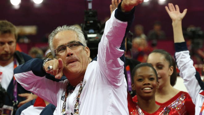 This file photo taken on July 31, 2012, shows US women gymnastics team's coach John Geddert celebrating with the rest of the team after the US won gold in the women's team of the artistic gymnastics event of the London Olympic Games.