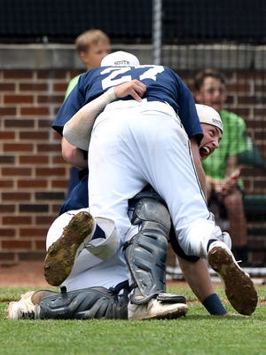 South pitcher Cameron Shook piles onto his grinning catcher, Davis Graham, after the last out.