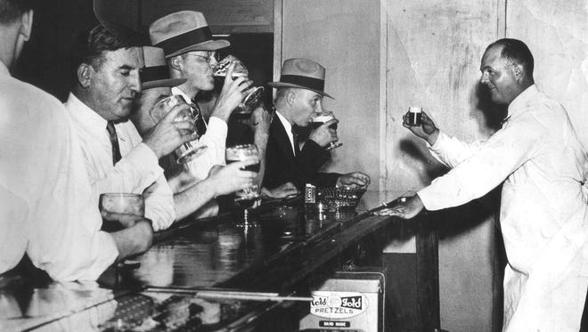 A bartender enjoys a round with his customers at a blind pig in Detroit during Prohibition. Blind pigs were lower-class, illegal  establishments that served alcohol;  speakeasies were higher-class, illegal businesses that also offered food and entertainment.
