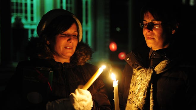 Jane Murphy, left, and Lois Valente of Grosse Pointe Park light candles at a vigil for Jane Bashara at Grosse Pointe South High School on Jan. 25, 2012. Police had discovered the body of the 56-year-old Grosse Pointe Park resident inside her vehicle in an east-side alley in Detroit earlier that day.
