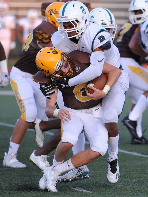 Rochester Adams quarterback Zach Soldan (8) is stopped by West Bloomfield defender Richard Sanders (2) in the first half during a high school football game Friday.