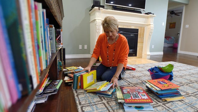 Home de-clutterer Dorothy Breininger works to organize children's books in the home of a client in Ladera Heights, Calif. When it comes to downsizing your belongings, famed Japanese organizer Marie Kondo suggests starting with your clothes first and then tackling books.