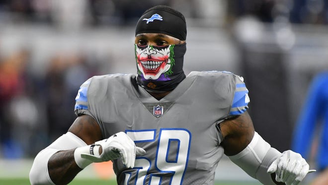 Lions' Tahir Whitehead stretches wearing a 'Joker' face mask while warming up before the game against the Bears.
