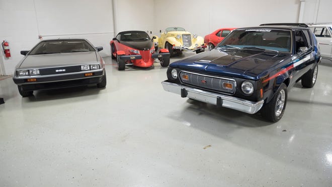 Cars of different makes and eras line the showroom.