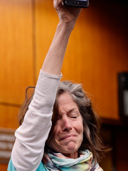 Tammy Bourque-Stemas of Dearborn cries while holding a cellphone photo of her daughter, Nassar abuse-victim Alexandra Bourque, who was an 11-year-old gymnast in the photo. She is now 27.