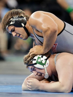 In this March 17, 2016, file photo, North Carolina State's Nick Gwiazdowski, top, controls Eastern Michigan's Gage Hutchison in a 285-pound match during the NCAA Division I wrestling championship in New York. Eastern Michigan plans to drop softball, men's swimming and diving, women's tennis and wrestling at the end of the spring season due to budget cutbacks.