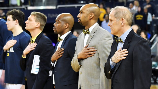 The coaching staff, from right, head coach John Beilein, assistant coaches Saddi Washington, Deandre Haynes and Luke Yaklich wear bow ties for Jude Stamper, a 12-year-old born with Arthrogryposis Multi-Congenital disorder. Stamper was 'signed' to the Wolverines and will be a fixture on their bench this winter.
