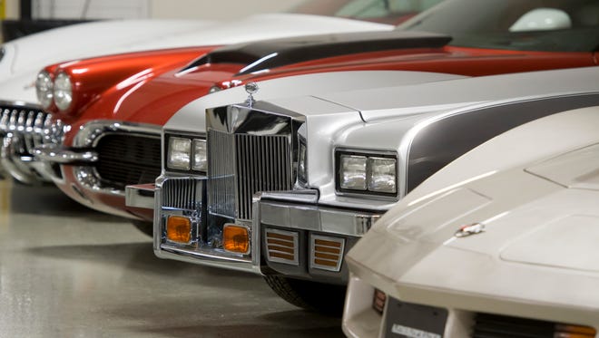 Cars of different eras line the showroom.