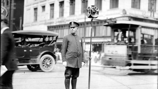 A police officer directs traffic in Detroit in the 1920s.  Detroit was among the first to have a police squad dedicated to traffic control.