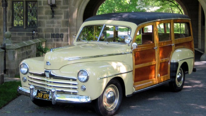 Vince Muniga of Grosse Pointe reworked every aspect of his 1948 Ford woodie wagon, restoring the wood and even ferreting out ”correct” rear fender splash guards. It is pictured here at the entrance to the Edsel and Eleanor Ford Estate in Grosse Pointe Shores.