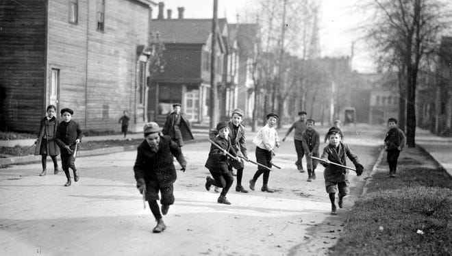 Children played in the streets, and were often struck by cars.  Above, boys play "shinny," a form of street hockey, on a Detroit street, circa 1910.