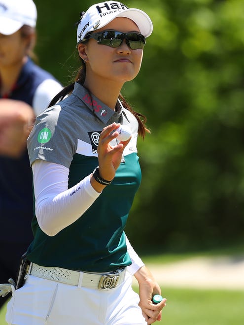 Minjee Lee of Australia waves to fans after putting out on the eight green during the first round.