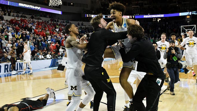 Michigan guard Jordan Poole (2) right celebrates with Michigan guard Charles Matthews, left, and teammates after the win.