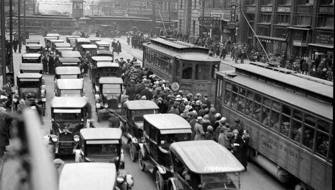 Getting on or off a streetcar like these at Michigan at Woodward avenues was a dangerous proposition in the 1920s, with lanes of traffic between the sidewalks and the streetcars.
