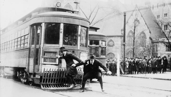 A streetcar safety demonstration on Woodward Avenue, circa 1925, shows the wrong way to disembark.  Streetcars ran in the middle of the streets, making it hazardous for pedestrians to get on and off.