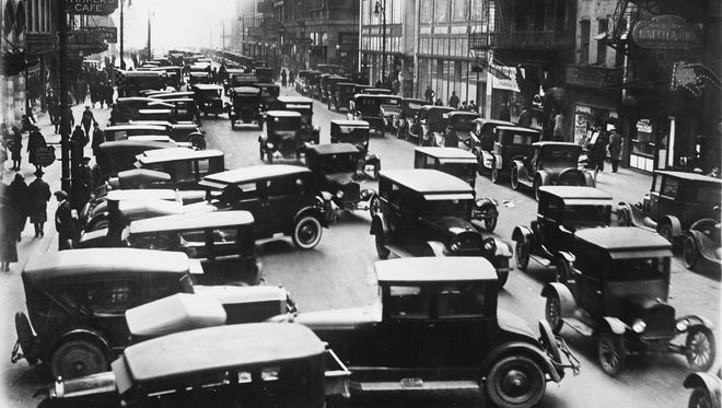 Traffic steers around cars that are double- parked on an unidentified Detroit street in 1915.  Parking availability was a big problem in the city.