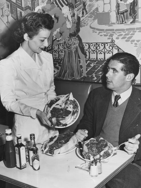 What did a world-class distance swimmer eat in 1949? Apparently big slabs of raw meat.  Jerry Kerschner of Ohio (nickname "Champ of the Gulf Coast Waters") poses at Carkins Restaurant with dietician Vicki Harrison.