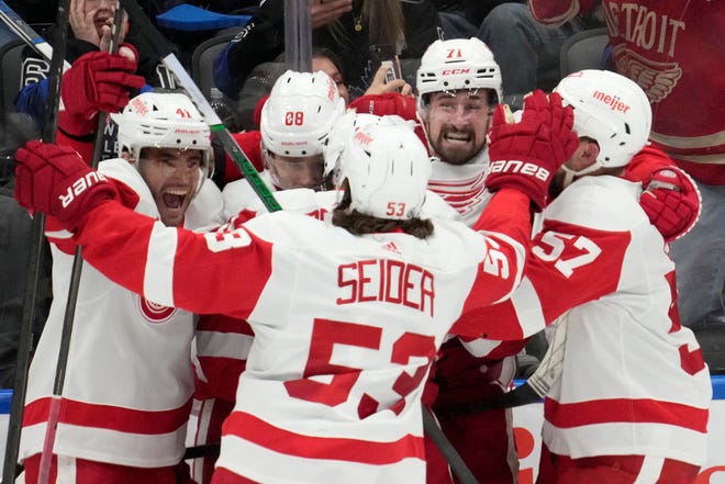Red Wings center Dylan Larkin (71) celebrates with teammates after against the Maple Leafs in overtime on Saturday in Toronto.