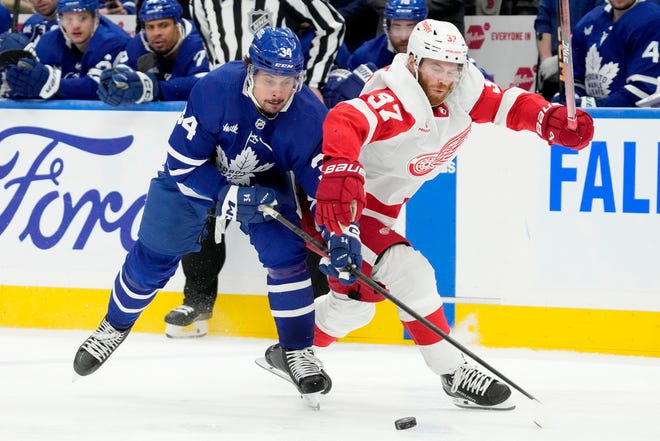 Maple Leafs center Auston Matthews (34) and Red Wings left wing J.T. Compher (37) vie for control of the puck during the second period.