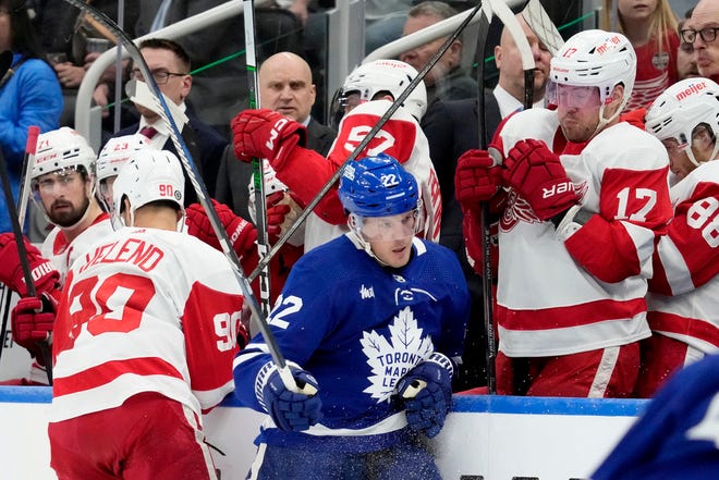 Red Wings players recoil as Maple Leafs defenseman Jake McCabe (22) is sent into the boards by Red Wings center Joe Veleno (90) during the first period.