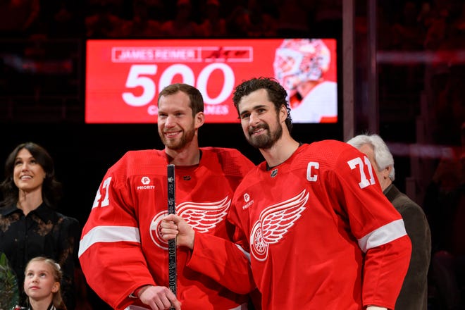 Detroit center Dylan Larkin, right presents goaltender James Reimer with a silver stick during a pregame ceremony honoring Reimer’s 500th NHL game during the first period.