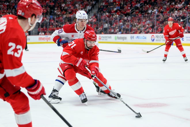 Detroit center Dylan Larkin keeps the puck away from Montreal left wing Juraj Slafkovsky during the first period.