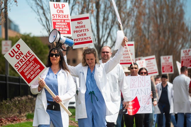 Dr. Michelle Wiener, center, raises her hands in the air while picketing with fellow physicians and physician assistants from the Ascension St. John Emergency Department as they begin a 24-hour strike on Thursday, April 18, 2024 at the hospital in Detroit.