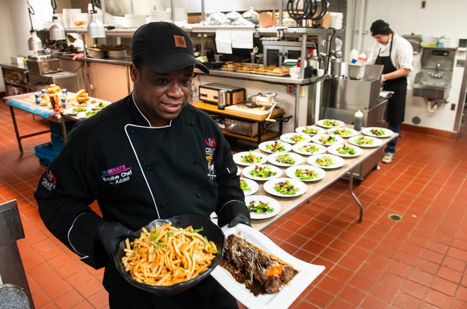 Omar Mitchell, executive chef at Table No. 2, an upscale restaurant in Detroit's Greektown, carries plates of food to the dining room on Thursday, April 18, 2024.