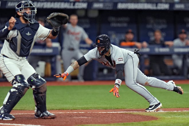 Detroit Tigers' Javier Baez scores in front of Tampa Bay Rays catcher Rene Pinto, left, on a throwing error by Jose Caballero during the fifth inning.