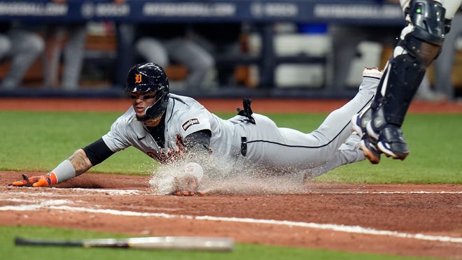 Detroit Tigers' Javier Baez scores on a throwing error by Tampa Bay Rays shortstop Jose Caballero as catcher Rene Pinto reaches for a high throw during the fifth inning.