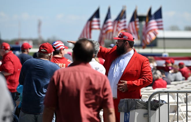 Taylor native Bradley Hodges, 34, of Saginaw, right, helps guide people to seating before the Donald Trump rally at Avflight Saginaw at MBS International Airport in Freeland, Mich. on May 1, 2024.