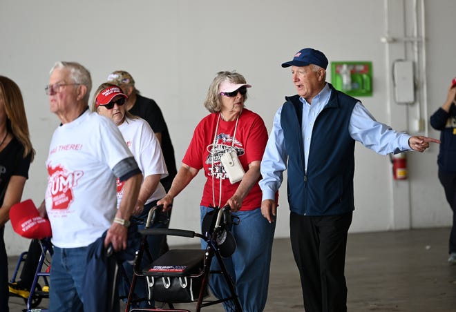 Former U.S. Rep Pete Hoekstra and Michigan Republican Chair, right, greets Trump supporter Kathy Routheaux of Mount Pleasant, in red, before the Donald Trump rally at Avflight Saginaw at MBS International Airport in Freeland, Mich. on May 1, 2024.