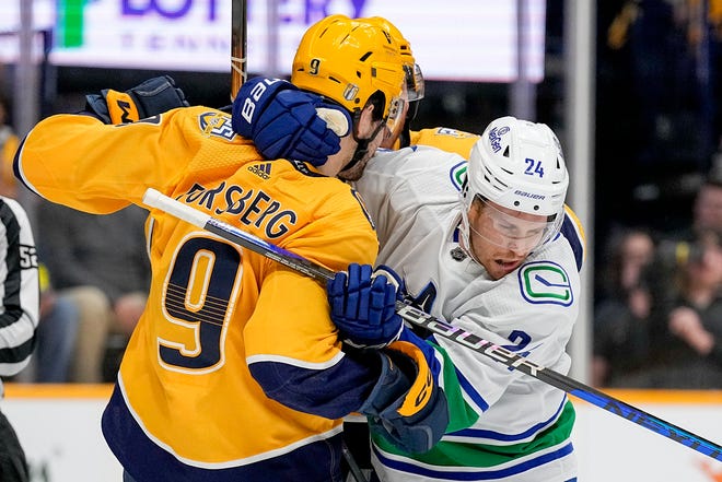 Ex-Red Wing Pius Suter, right, is checked by left wing Filip Forsberg during the first period in Game 6 of the first-round playoff series on Friday in Nashville, Tenn.