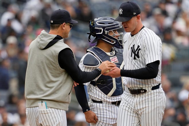 New York Yankees manager Aaron Boone, left, removes pitcher Caleb Ferguson, right, from the game in the sixth inning.